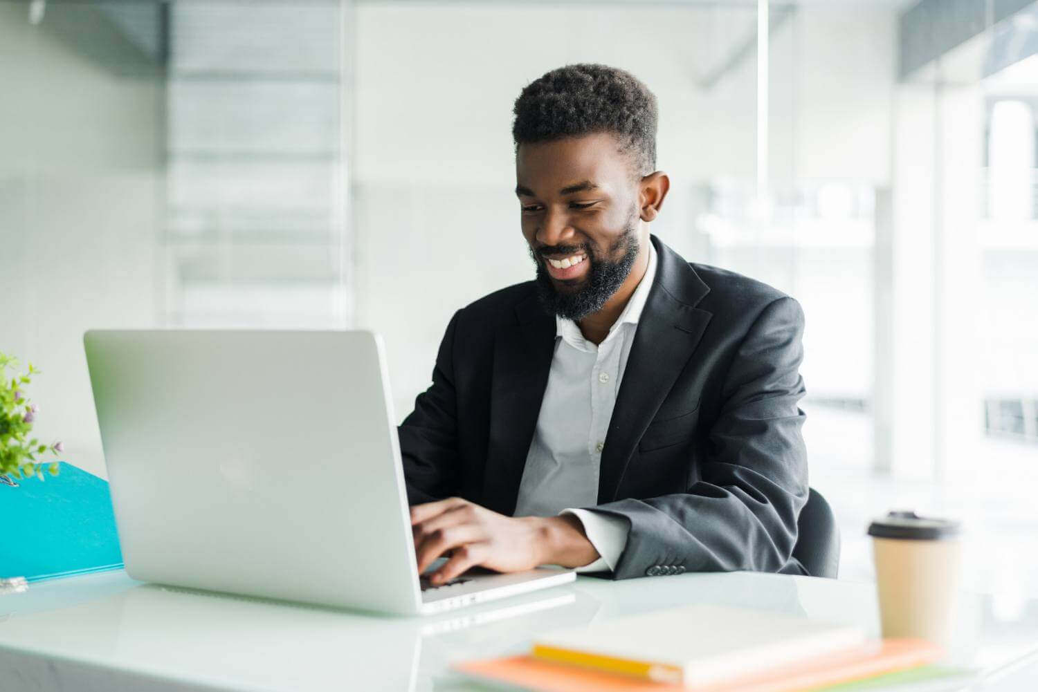 pessoa de terno sentado à frente de um notebook e realizando uma revisão de conteúdo para os sites dos seus clientes
