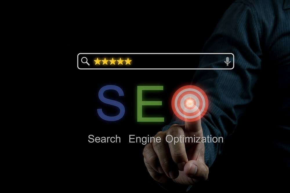 Pessoa com um dedo clicando no ícone de meta onde sinaliza o objetivo de estratégias de SEO para posicionar um site de uma empresa no Google.